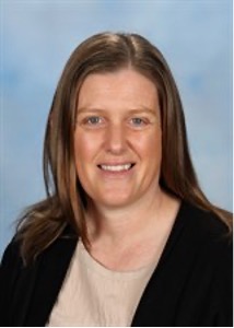 Person smiling in professional portrait, blue background.