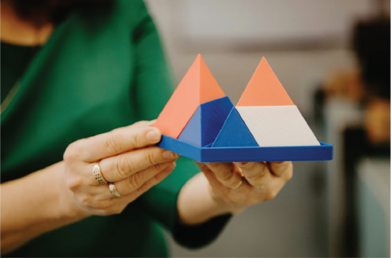 Person holding a 3D geometric pyramid model