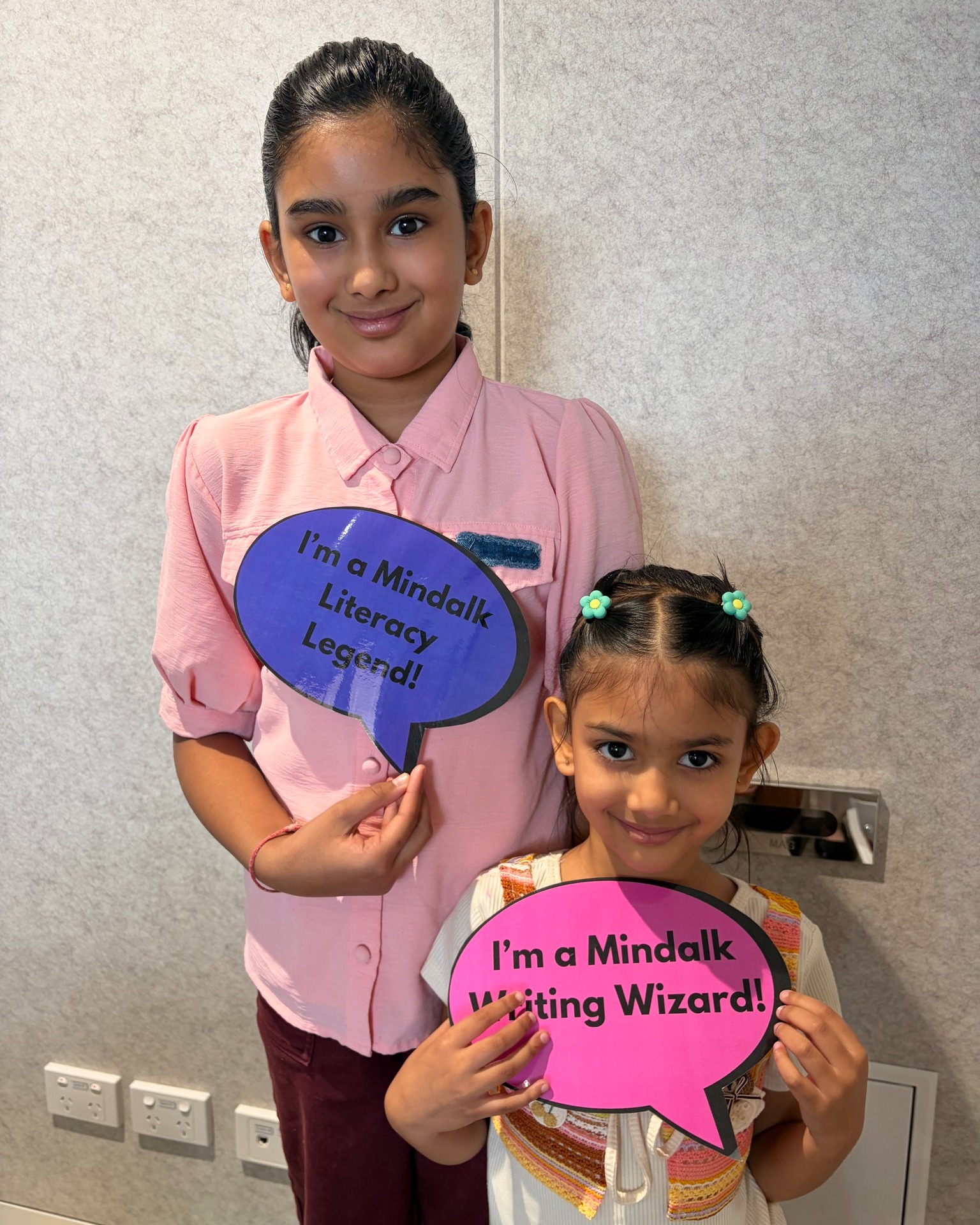Two children holding literacy award signs.