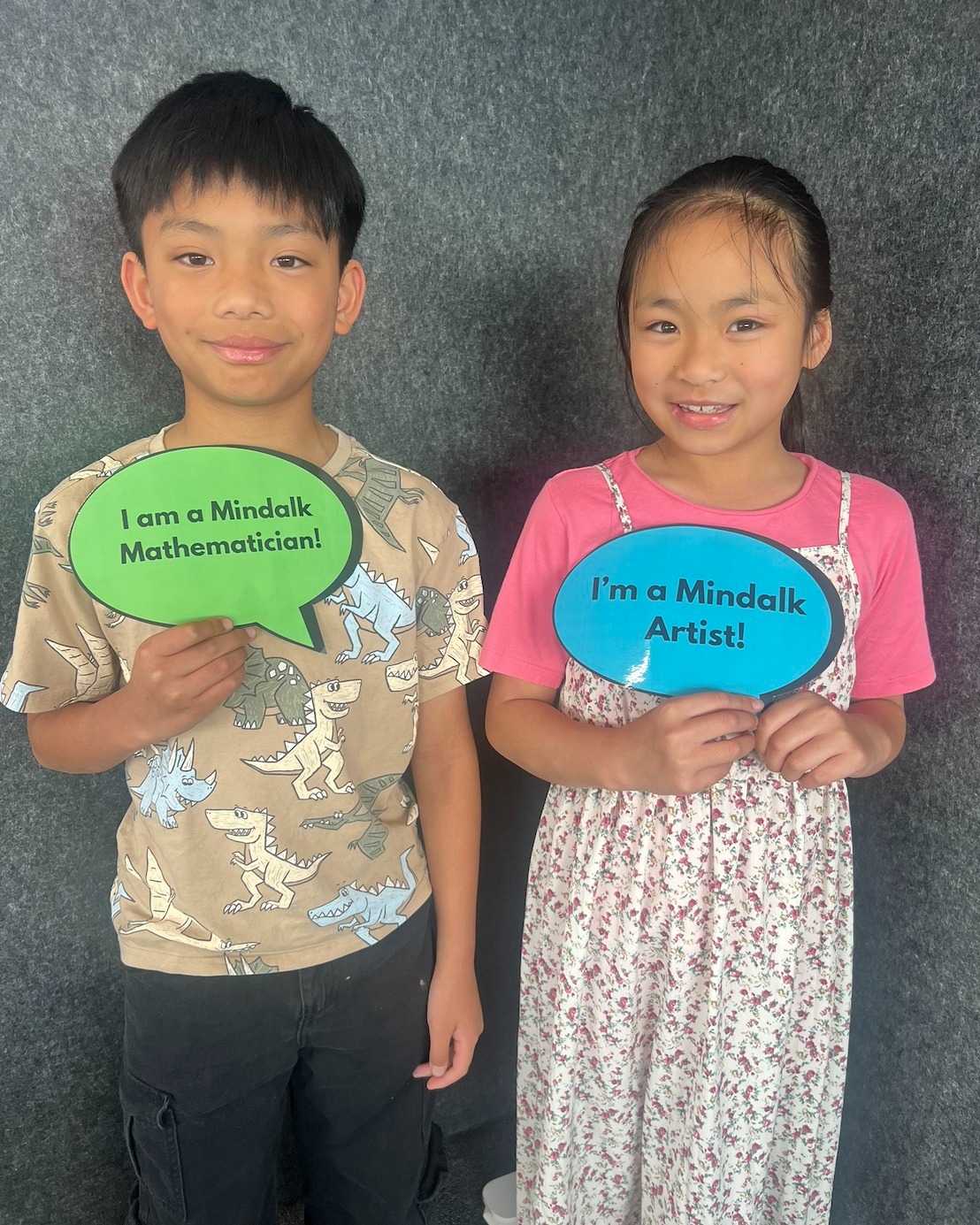 Children holding Mindalk mathematician and artist signs.