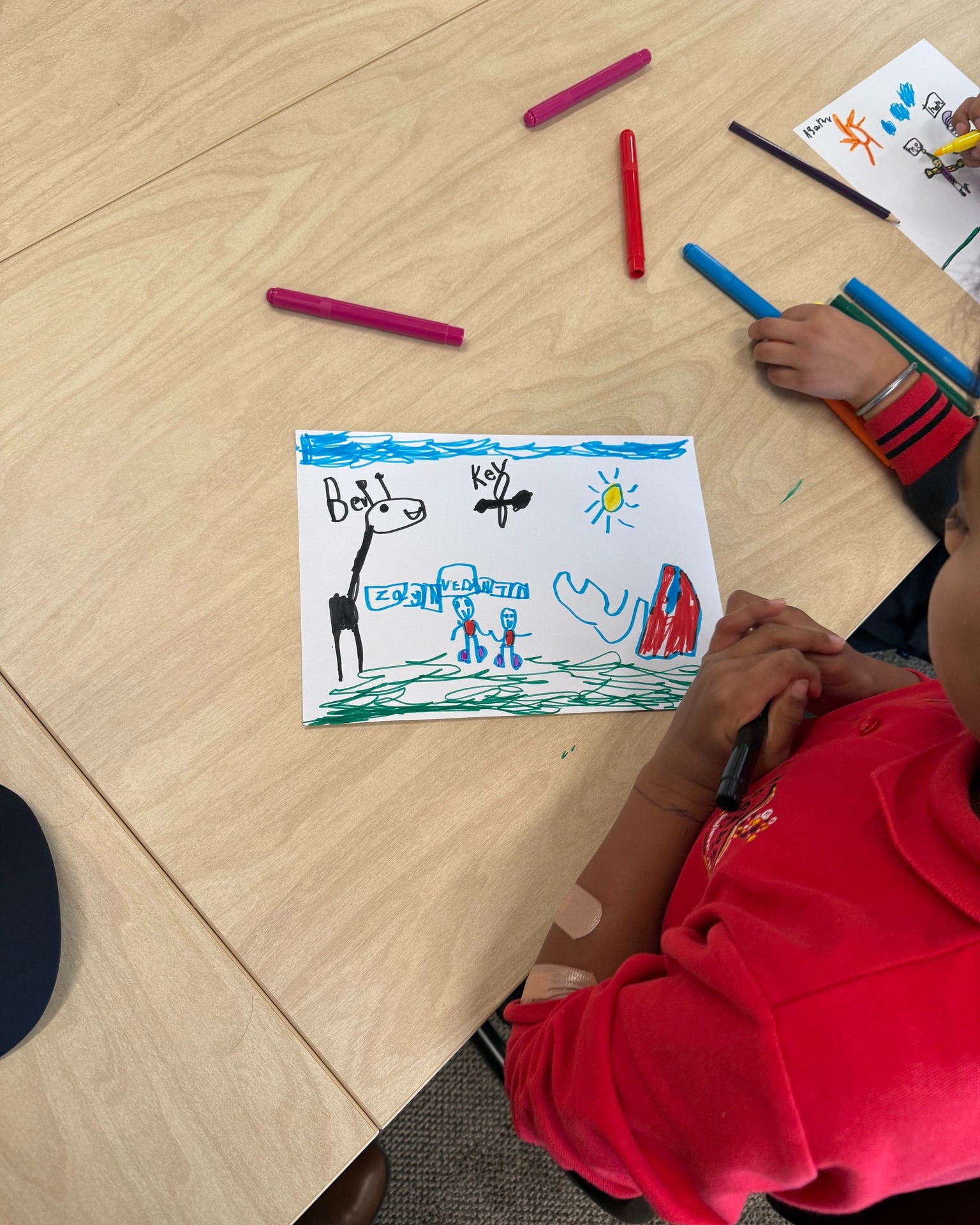 Child creating colourful drawings at a table