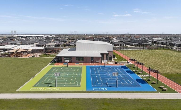 Modern school campus with outdoor courts and fields.