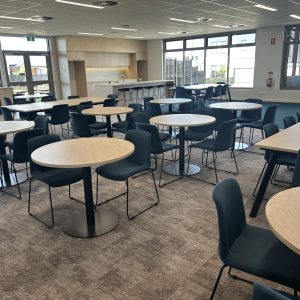 Modern dining area with round tables and chairs.