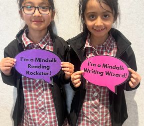 Young students holding Mindtalk encouraging signs.